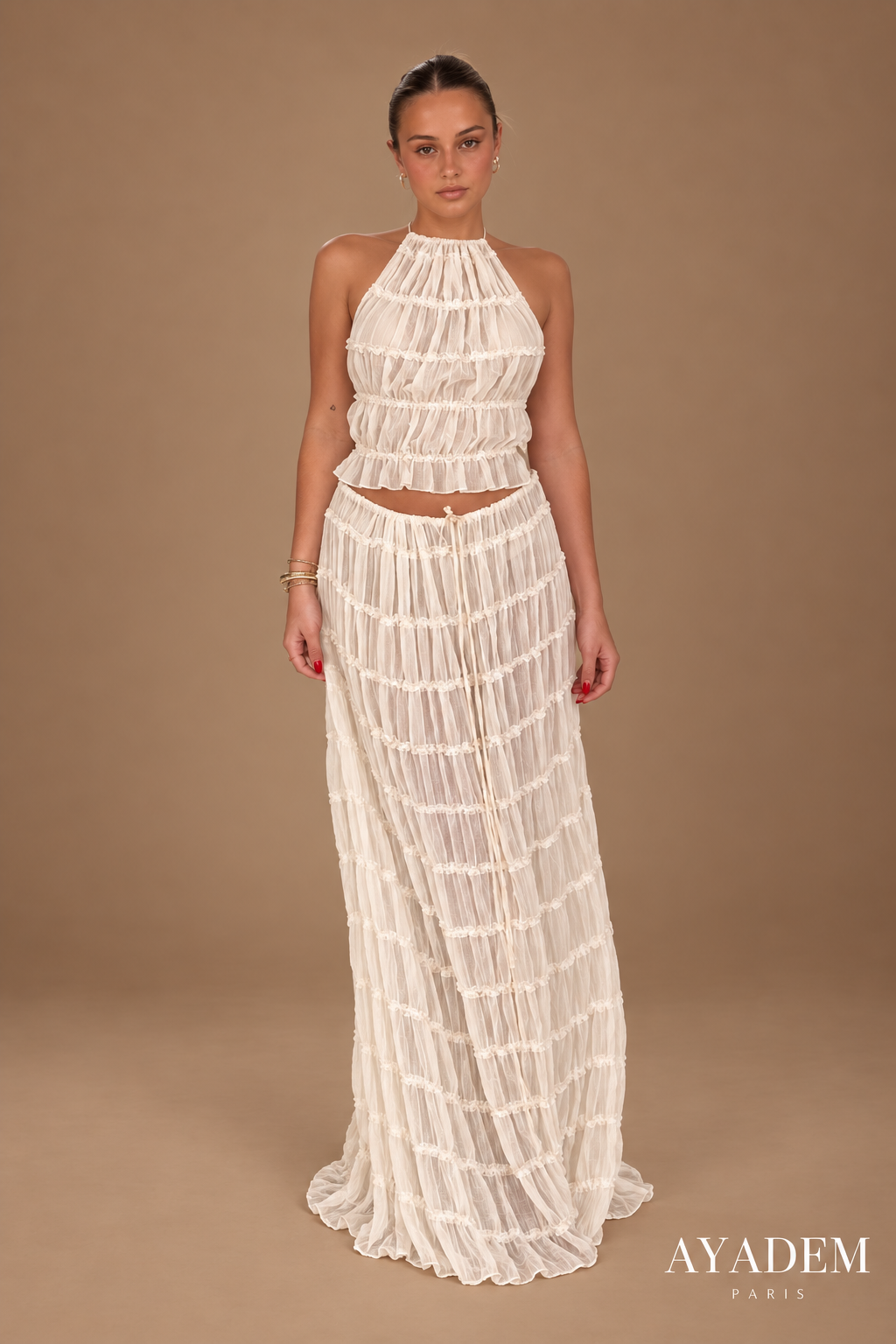Alba, ensemble beige à fronces, top dos-nu et jupe longue, sur fond studio taupe.